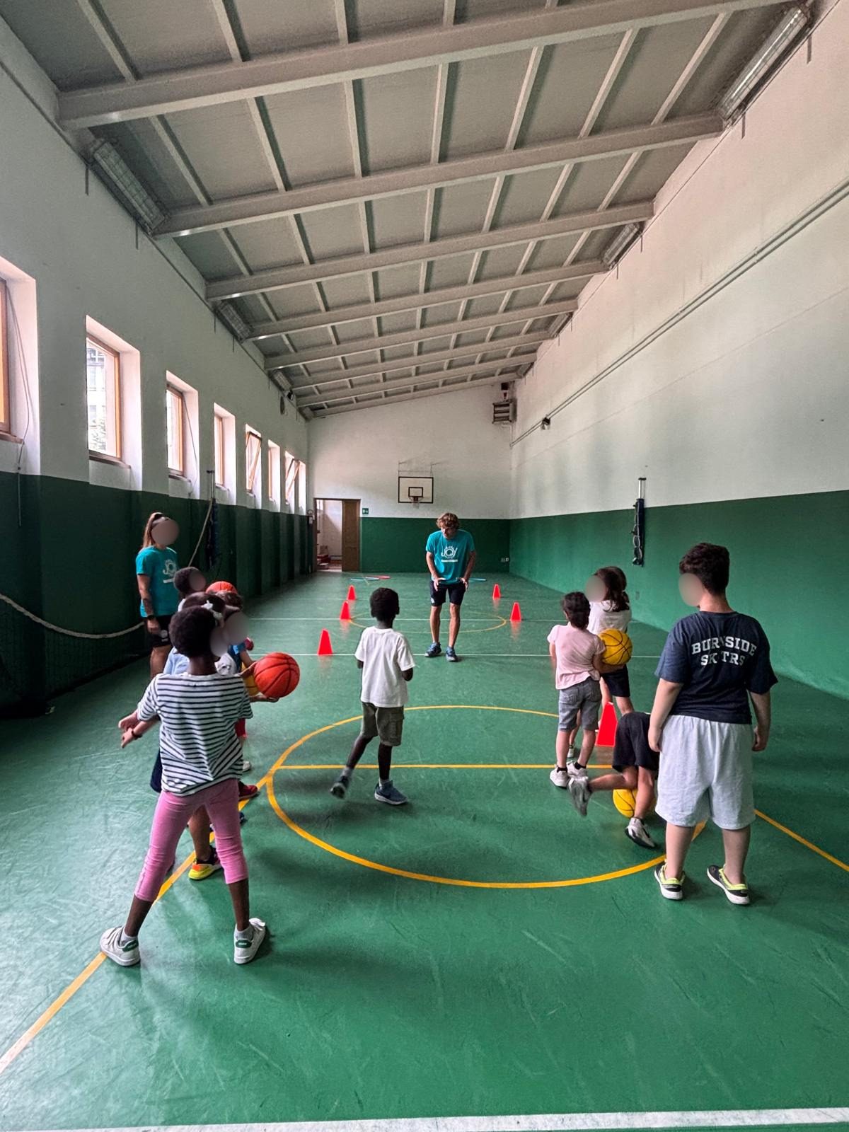 Bambini che giocano in palestra durante il centro estivo